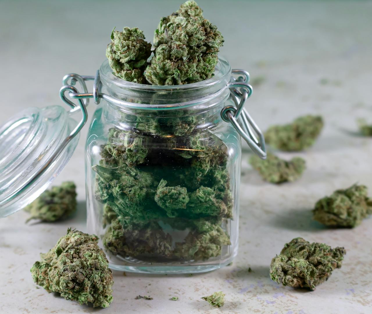 Close-up of cannabis buds stored in a glass jar, symbolizing herbal medicine and lifestyle.